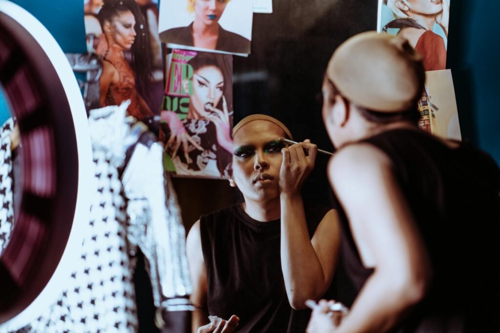 focused ethnic theater artist applying makeup on face